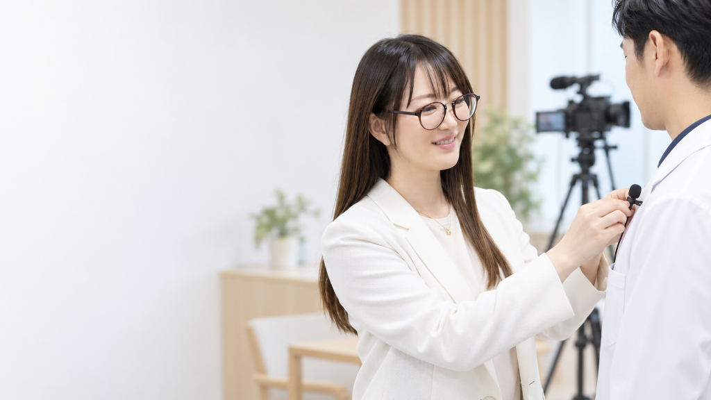 撮影前に医師へピンマイクを取り付ける発信ディレクター